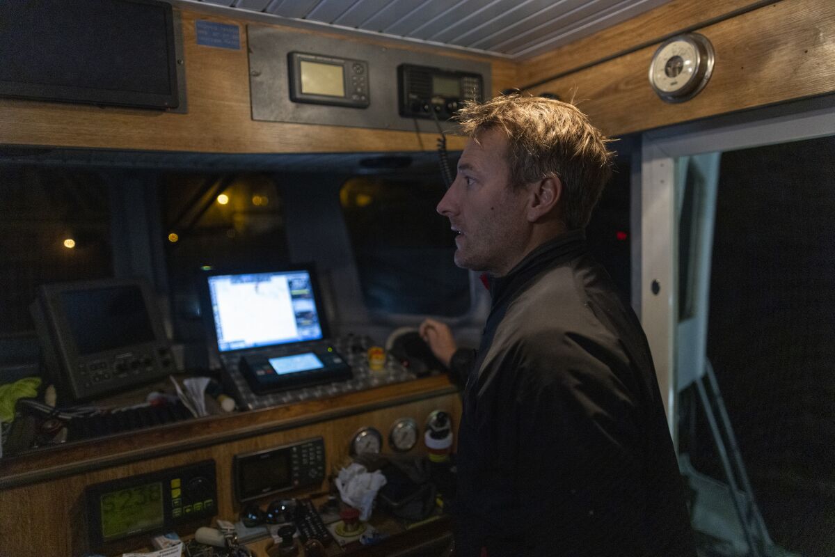 French fisherman Herman Outrequin, who does not have a license to fish in the U.K waters, stands in the cabin of his trawler in the port of Granville, Normandy, Wednesday, Nov. 3, 2021. Outrequin gave up his fishing company job and went independent in 2019 to have more time for his newborn son. But he hadn’t reckoned with the post-Brexit spat about fishing rights between Paris and London. (AP Photo/Jeremias Gonzalez)