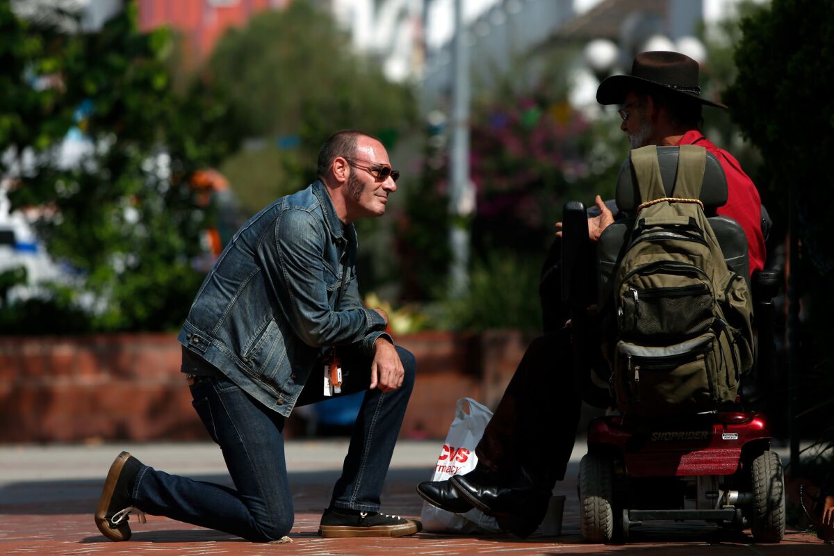 Sean Romin, left, an addiction specialist who's been clean for 15 years, speaks with Michael Welch in downtown Los Angeles.
