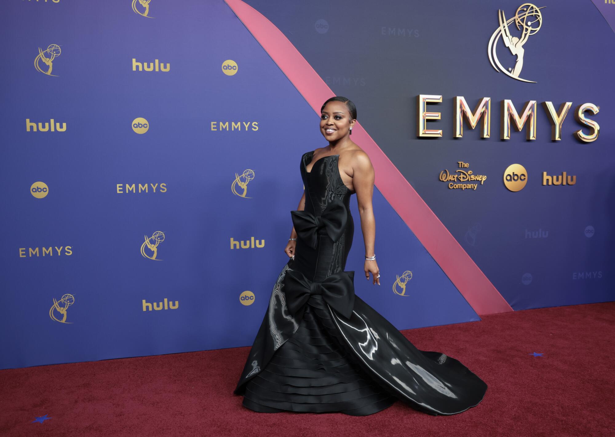 Quinta Brunson wears a black gown with bows. 