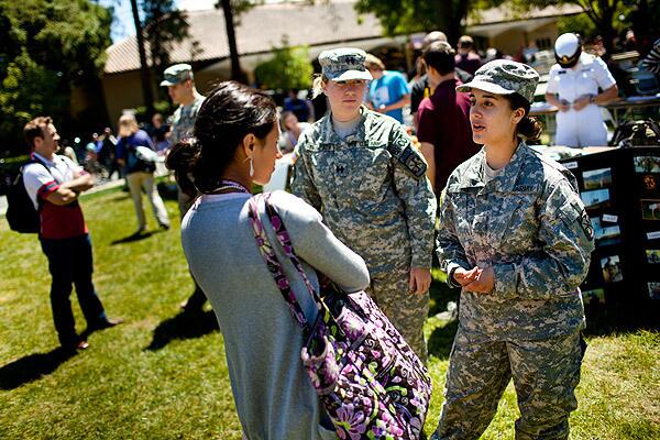 Kaitlyn Benitez-Strine, 17, speaks with ROTC representatives Anna Thompson, left, and Isabel Lopez at Stanford University. See full story