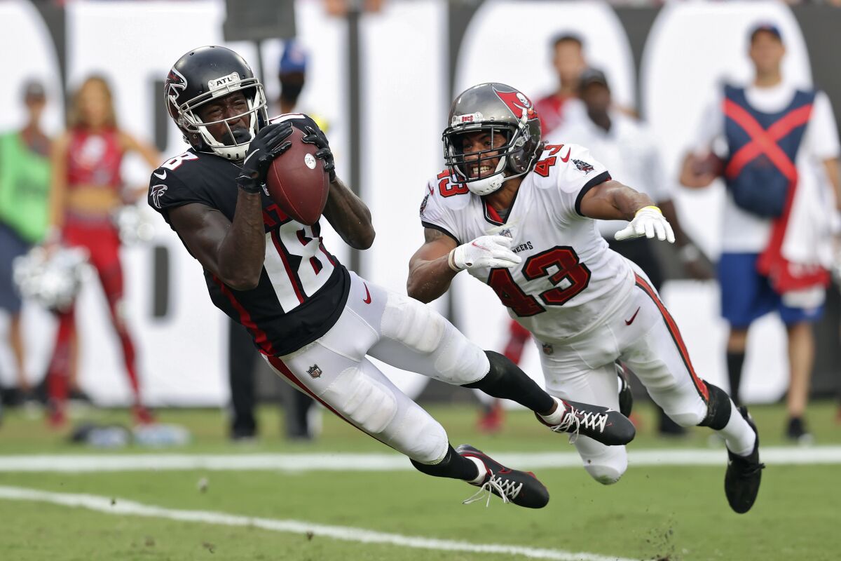 FILE - Atlanta Falcons wide receiver Calvin Ridley (18) makes a diving touchdown reception in front of Tampa Bay Buccaneers defensive back Ross Cockrell (43) during the second half of an NFL football game Sunday, Sept. 19, 2021, in Tampa, Fla. Falcons wide receiver Calvin Ridley has been suspended for the 2022 season for betting on NFL games in the 2021 season. The suspension announced by NFL commissioner Roger Goodell on Monday, March 7, 2022, is for activity that took place while Ridley was away from the team while addressing mental health concerns.(AP Photo/Mark LoMoglio, File)