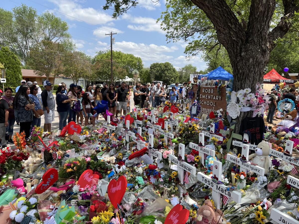 A giant memorial containing many crosses with names and flowers. 