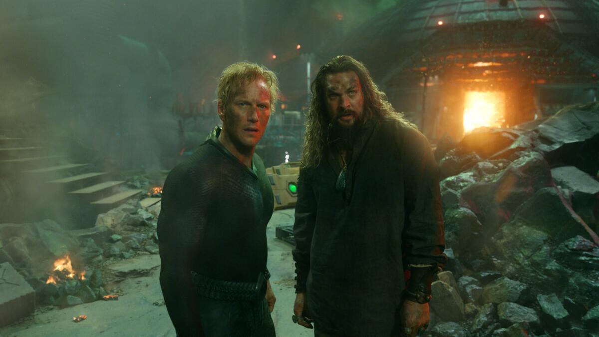 Two super-powered Atlantean warriors are surrounded by rubble and fire. 