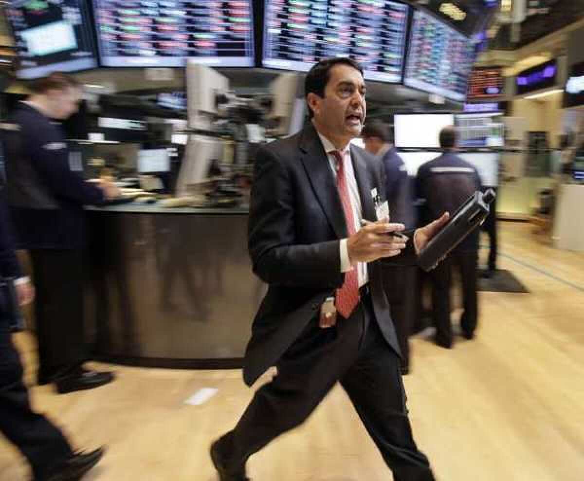 As stocks opened on a downward trend Friday, trader Mark Muller hustles across the floor of the New York Stock Exchange.