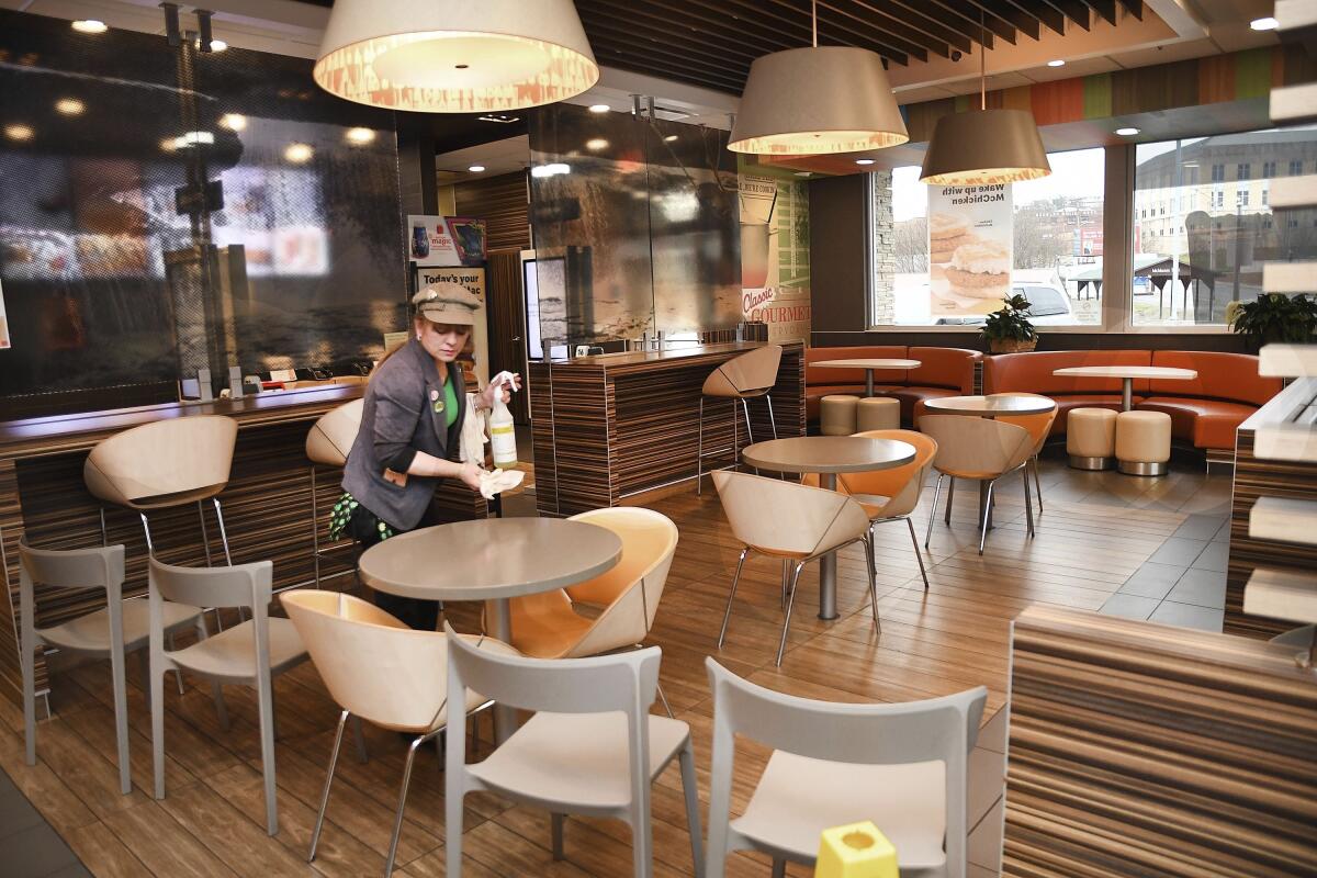 Manager Lori Harper wipes down tables in a McDonald's restaurant in Beckley, W.Va., on Tuesday.