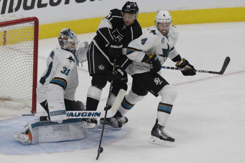 Kings winger Andy Andreoff tries to deflect the puck past Sharks goalie Martin Jones as he is covered by defenseman Brenden Dillon during the third period on Thursday.