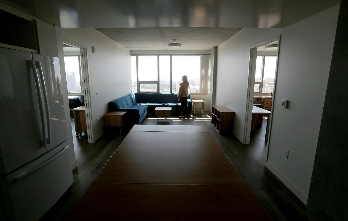 A person stands by the window in a two-bedroom suite 