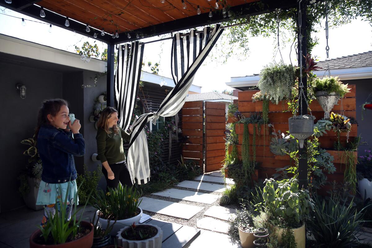 Allison Glatstein helps daughter Nili take a photograph of the vertical garden.