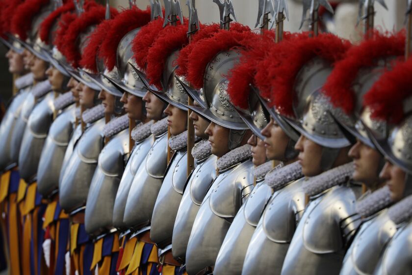 FILE - In this Oct. 4, 2020 file photo, Vatican Swiss Guards stand attention at the St. Damaso courtyard on the occasion of their swearing-in ceremony, at the Vatican, Sunday, Oct. 4, 2020. On Monday, Oct. 12, 2020, the Vatican said in a statement that four Swiss Guards have tested positive for the coronavirus, as the surge in infections in surrounding Italy enters the Vatican walls. (AP Photo/Gregorio Borgia, file)