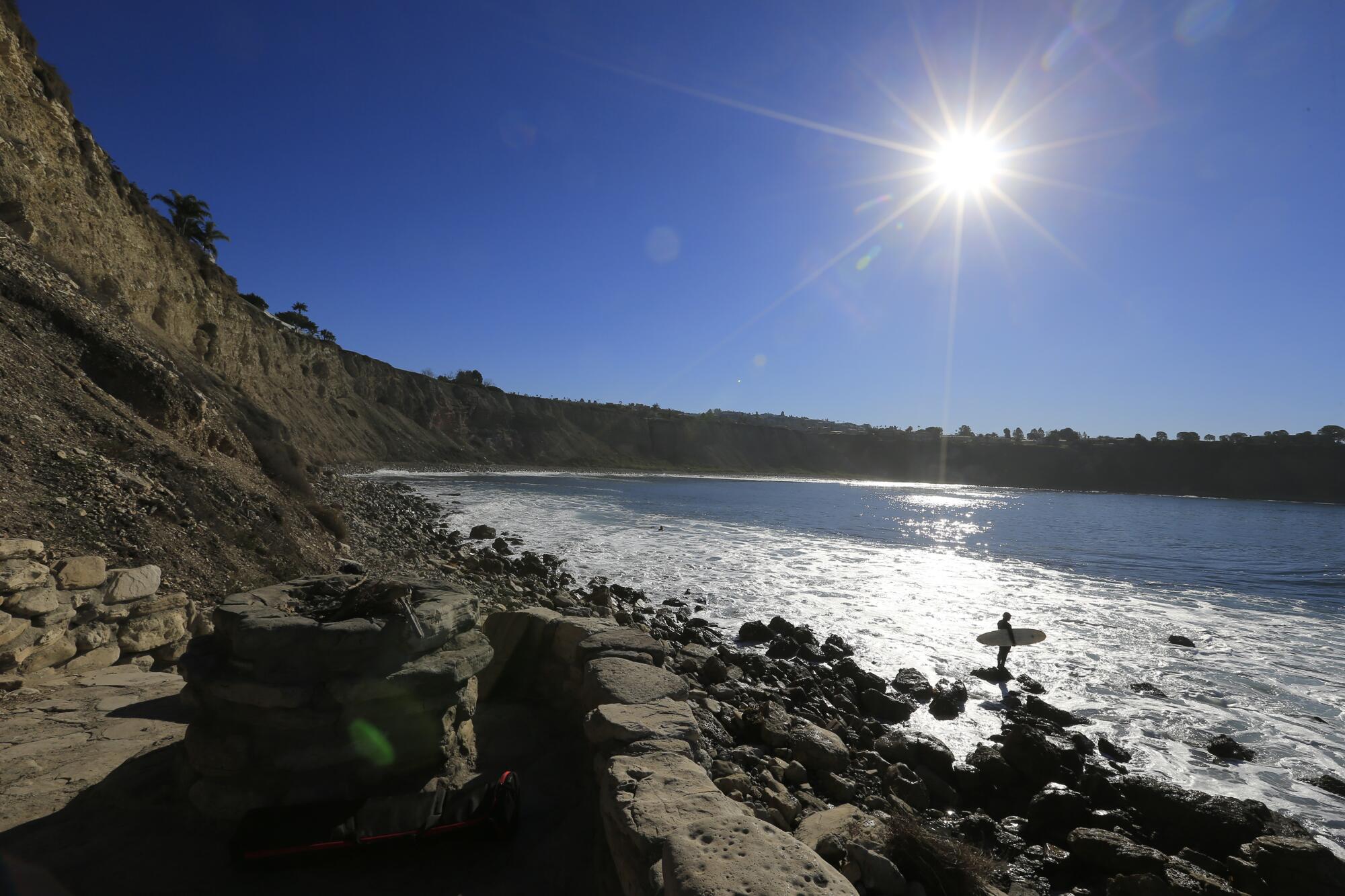 A surfer heads into the water at Lunada Bay in February 2016.