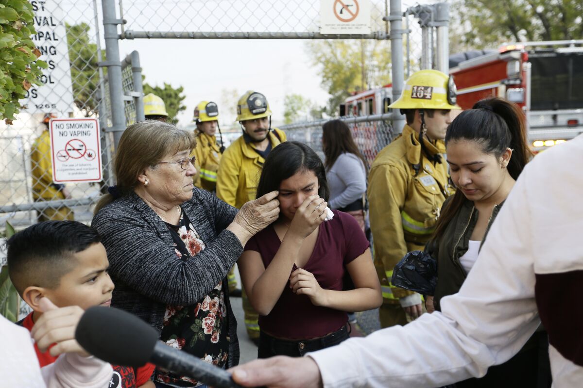 Student Marianna Torres, 11, center, cries as she evacuates Park Avenue Elementary School after jet fuel fell on the school in Cudahy.