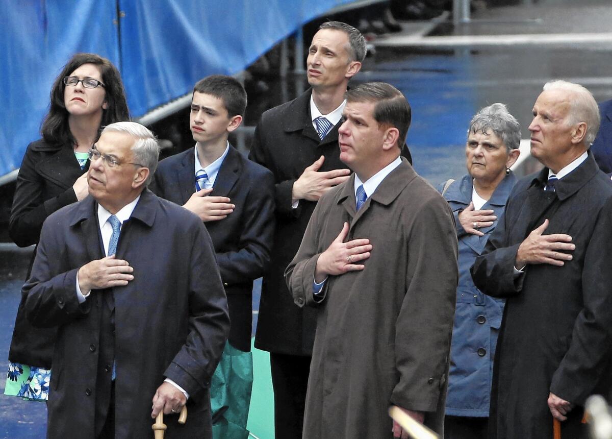 Former Boston Mayor Thomas Menino, left, Boston Mayor Marty Walsh and Vice President Joe Biden attend a remembrance ceremony at the 2014 Boston Marathon's finish line. Menino, who led the city through the aftermath of the 2013 bombings, died Thursday. He was 71.