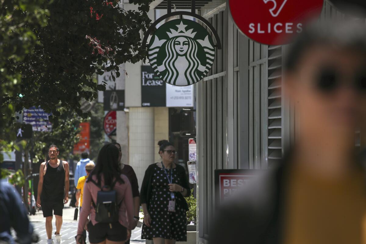 People walk in front of a Starbucks in downtown Los Angeles
