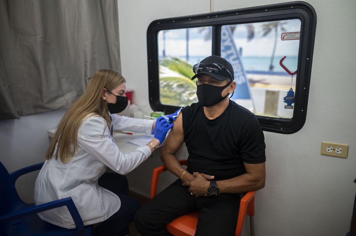 A healthcare worker inoculates 59 year-old Raymon Diaz with a dose of the Johnson & Johnson COVID-19 vaccine during a vaccination campaign as part of the “Noche de San Juan” festivities, a traditional all-day celebration to mark the birth of St. John the Baptist, at the Ultimo Trolley public beach in San Juan, Puerto Rico, Wednesday, June 23, 2021. This year COVID-19 vaccines will be available to devotees heading to the beach to celebrate the saint’s June 24th feast day. (AP Photo/Carlos Giusti)