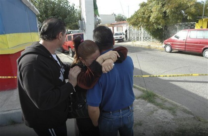 Relatives of journalist Armando Rodriguez embrace each other outside his home after he was gunned down by unknown assailants in Ciudad Juarez, Mexico, in the border with the U.S., Thursday, Nov. 13, 2008. Rodriguez, who had covered crime for 10 years in Juarez, working for El Diario newspaper, was killed amid a rising wave of drug violence.(AP Photo)