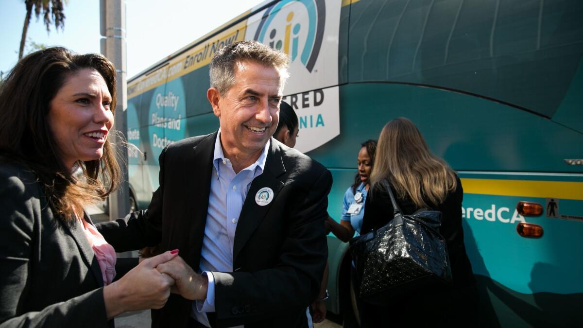 Covered California executive director Peter V. Lee, center, arrives at a news conference in 2015.