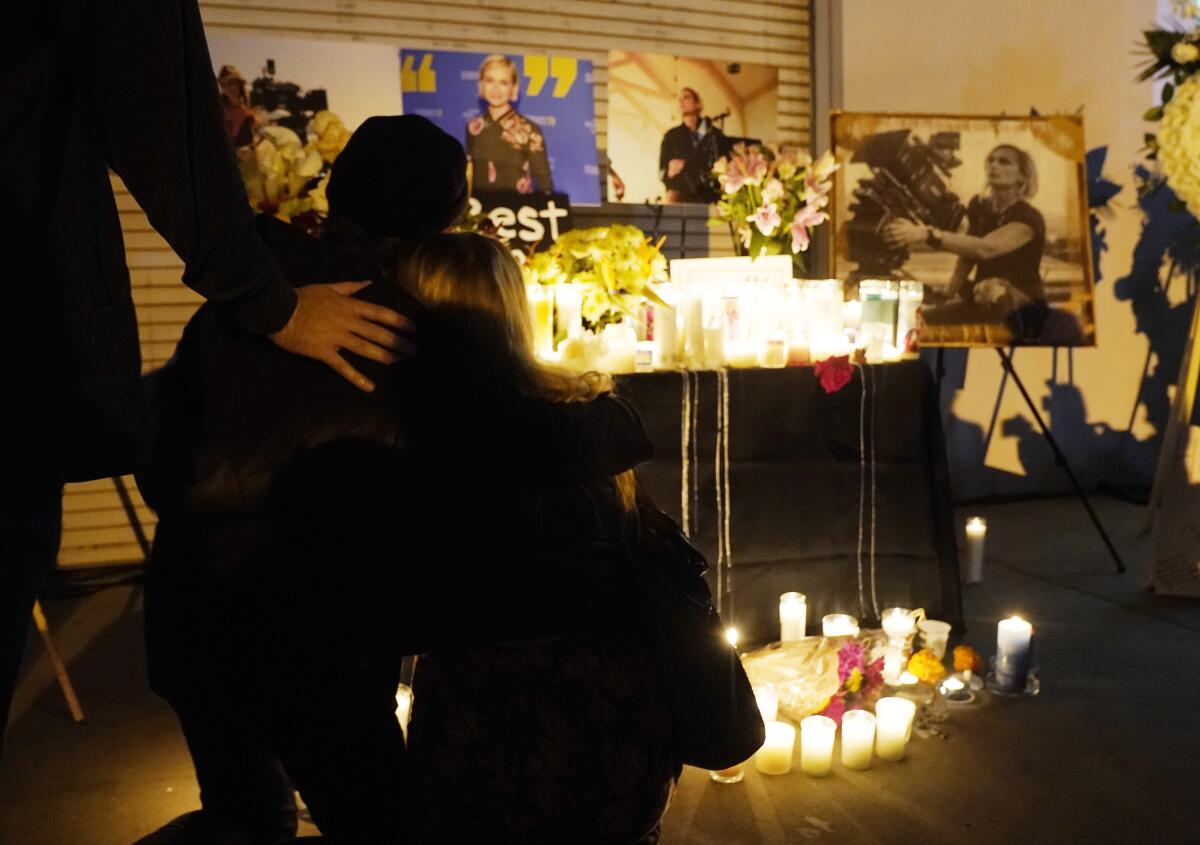 Lighted candles are placed near photos of deceased cinematographer Halyna Hutchins.