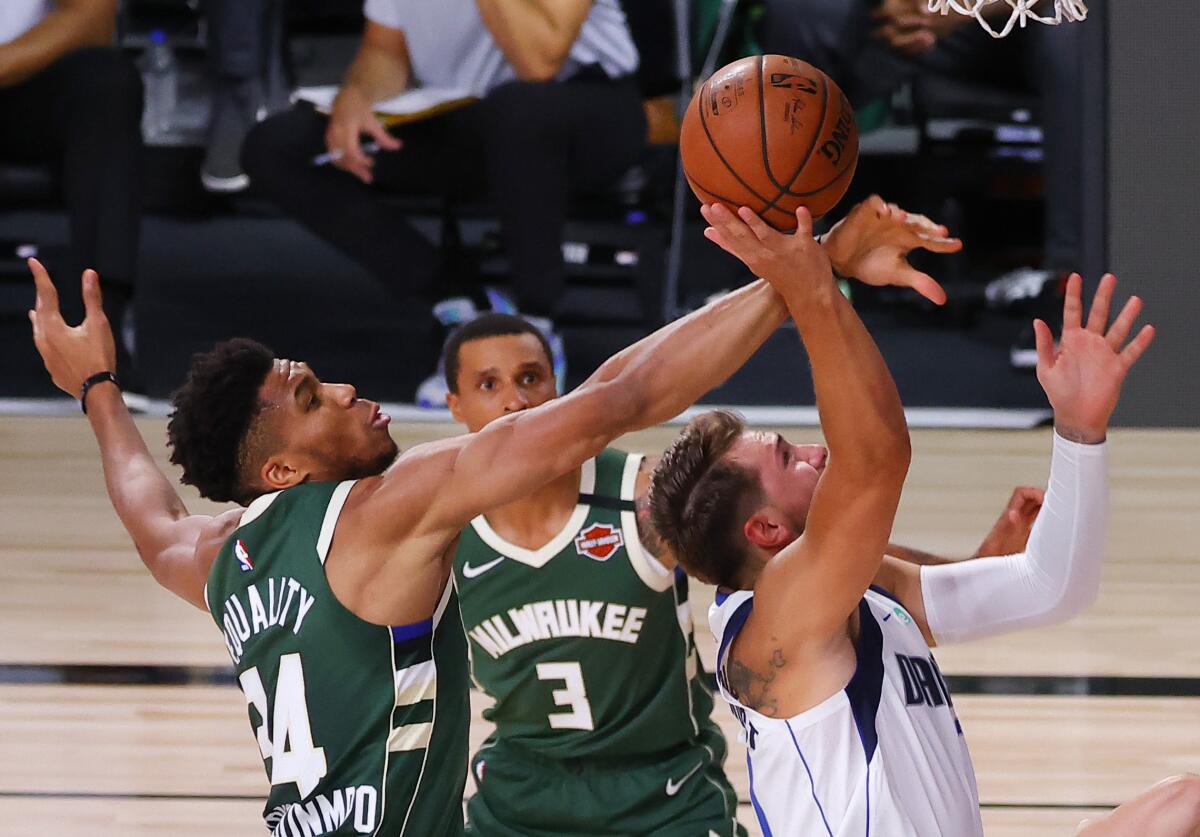 The Milwaukee Bucks' Giannis Antetokounmpo blocks a shot by the Dallas Mavericks' Luka Doncic.