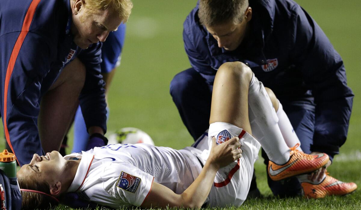 U.S. forward Alex Morgan is tended to by trainers after sustaining an injured left ankle in the game against Guatemala on Friday night.