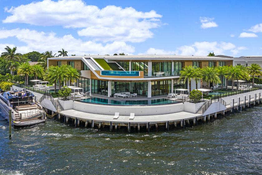 Built in 2019, the wood-and-glass mansion includes 343 feet of water frontage and four infinity pools, including one fed by a waterfall from the roof.