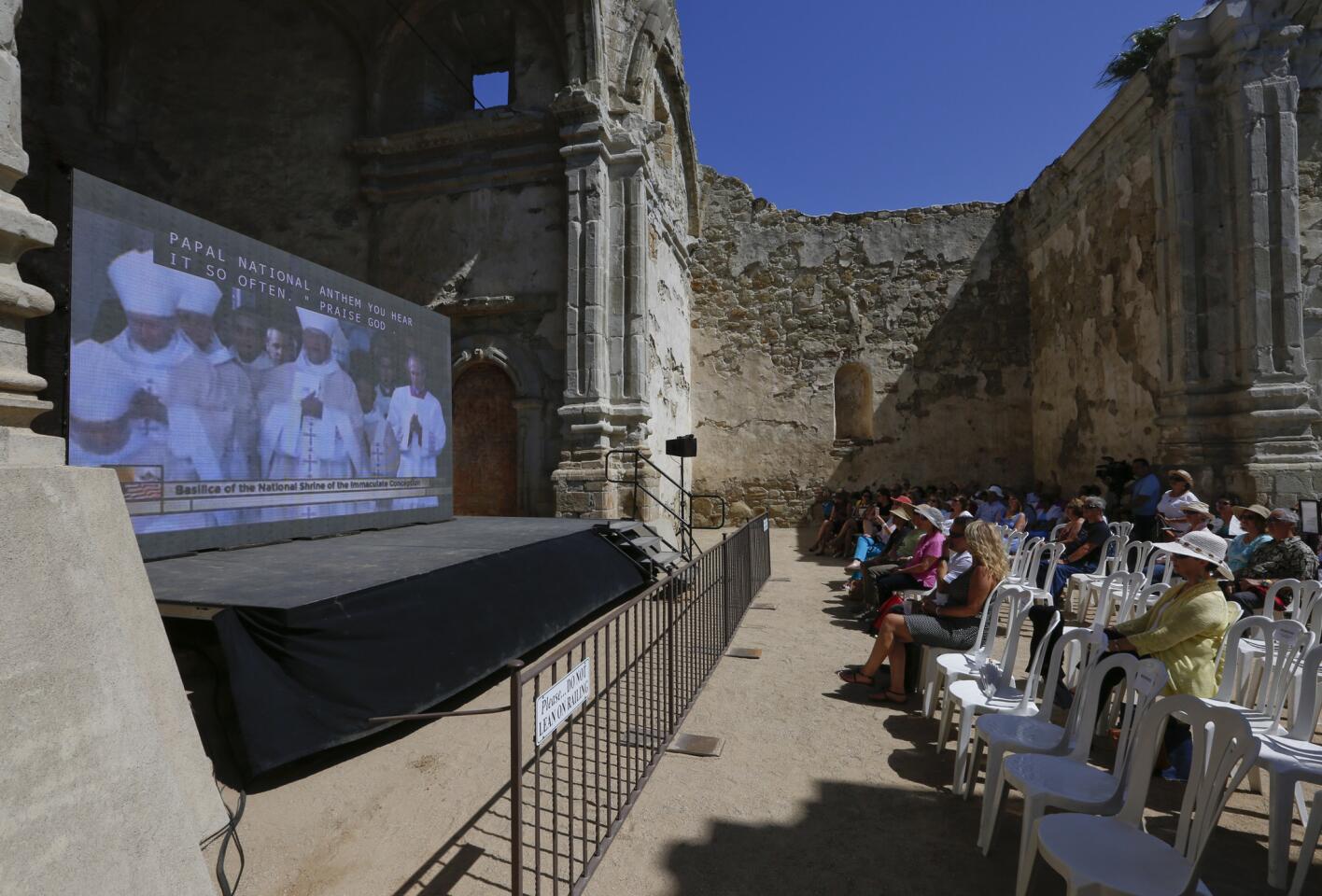 People gather at Mission San Juan Capistrano to watch a live video stream of the canonization of Father Junipero Serra. Pope Francis declared Serra's sainthood during services in Washington, D.C. on Sept. 23.