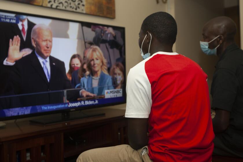 Kenianos miran por televisión la ceremonia de investidura del presidente estadounidense Joe Biden el miércoles 20 de enero del 2021, en Nairobi. (AP Foto/Sayyid Abdul Azim)