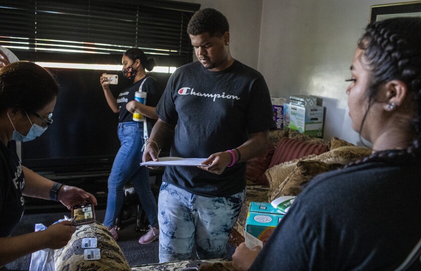 Tomajae Tolliver, center, looks over paperwork with his girlfriend, Katherine Cordova.