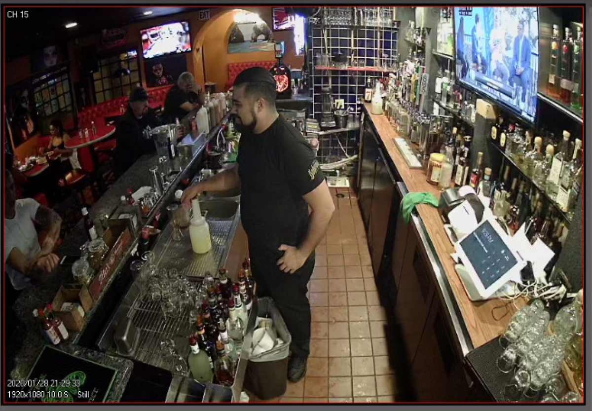 A bartender talks to a customer in surveillance footage