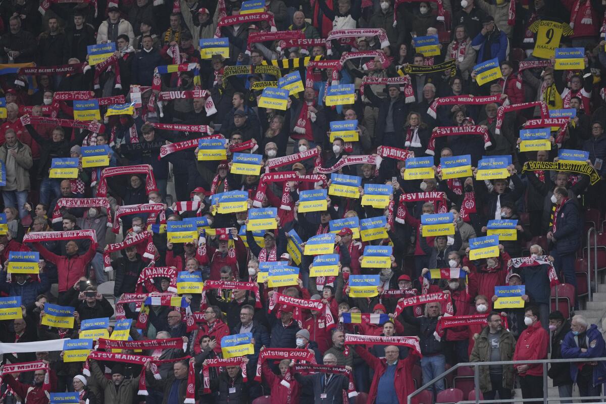 Hinchas del club alemán Mainz despliegan mensajes de apoyo a Ucrania previo al partido de la Bundesliga 