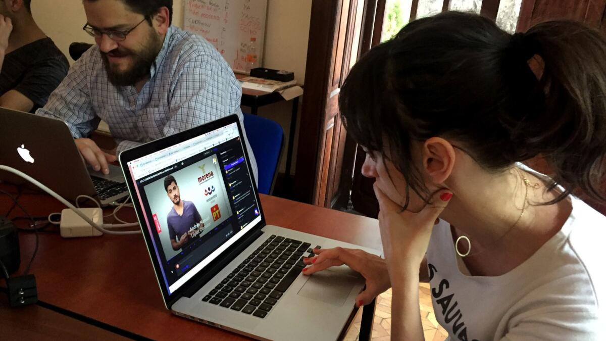 Alba Mora Roca, right, a journalist with Verificado 18, works on a video at the group's Mexico City office. The group's staff is fact-checking fake news ahead of Mexico's July 1 presidential vote.