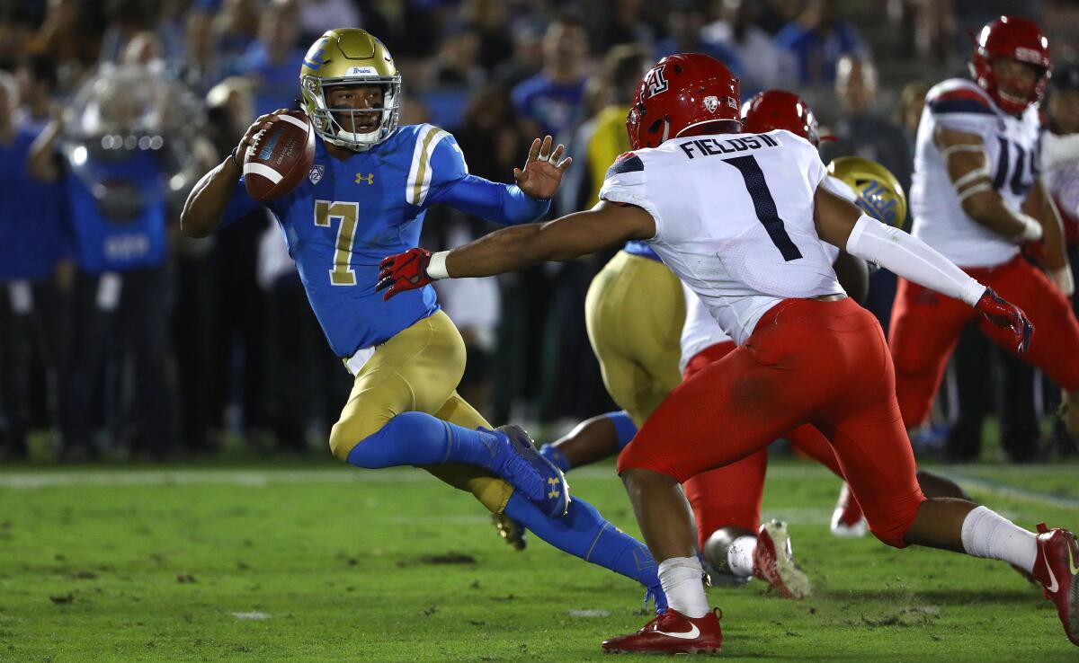 UCLA quarterback Dorian Thompson-Robinson tries to avoid Arizona linebacker Tony Fields II in October.