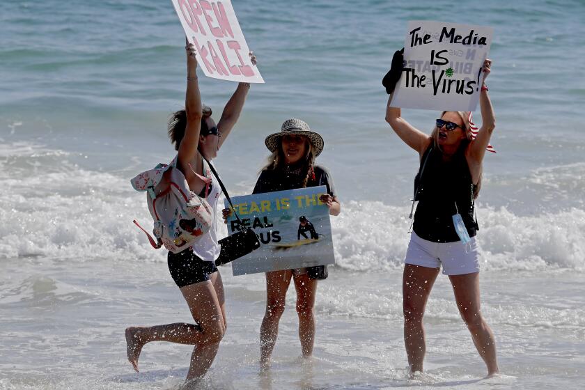 LAGUNA BEACH, CALIF. - MAY 2, 2020. Protesters stage a temporary takeover of the beach in Laguna Beach on Saturday, May 2, 2020. California Gov. Gavin Newson ordered a hard closure of Orange County beaches this weekend. But responding to public pressure in recent days, Newson has implied that a gradual reopening of beaches, parks and the economy following the coronavirus lockdown could begin as early as next week. (Luis Sinco/Los Angeles Times)