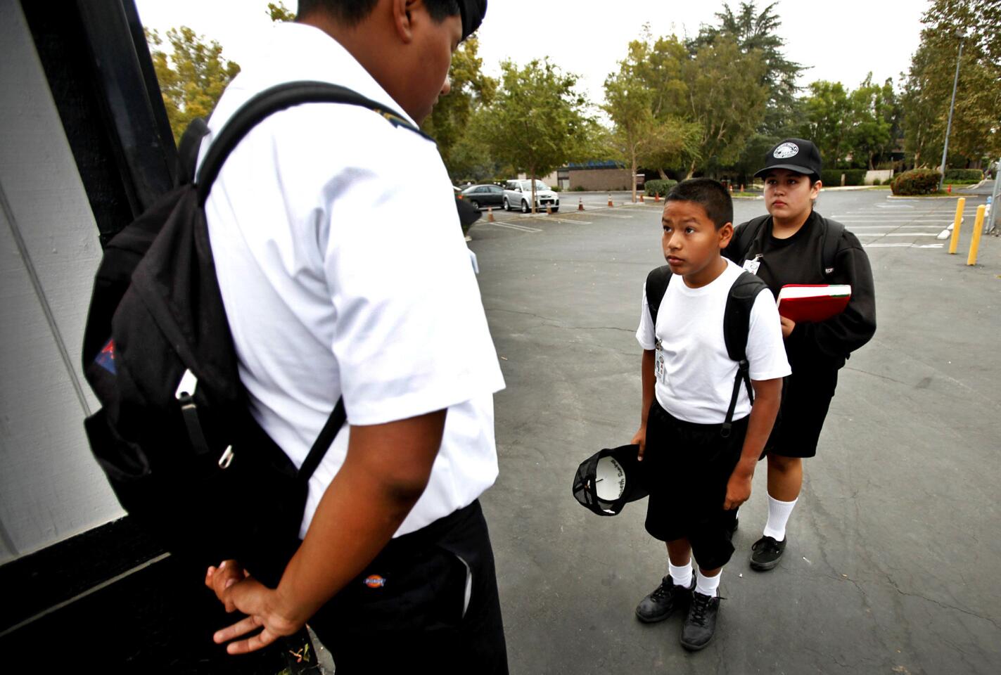 North Valley Military Institute sixth-grade student Joseph Ramirez, right, is inspected by 10th-grade student Robert Ramirez, left, before being allowed to enter the campus at the start of the school day on Oct. 2.