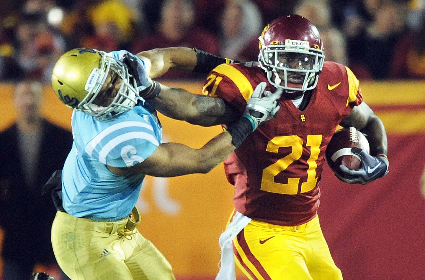 USC running back Allen Bradford stiff arms UCLA' safety Tony Dye for a big gain during the second quarter of a game at the Coliseum on Nov. 28, 2009.