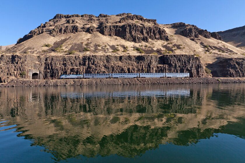 An Amtrak train rolls by the north bank of the Columbia River in Wishram, Wash., in the Portland section of the Empire Builder route.