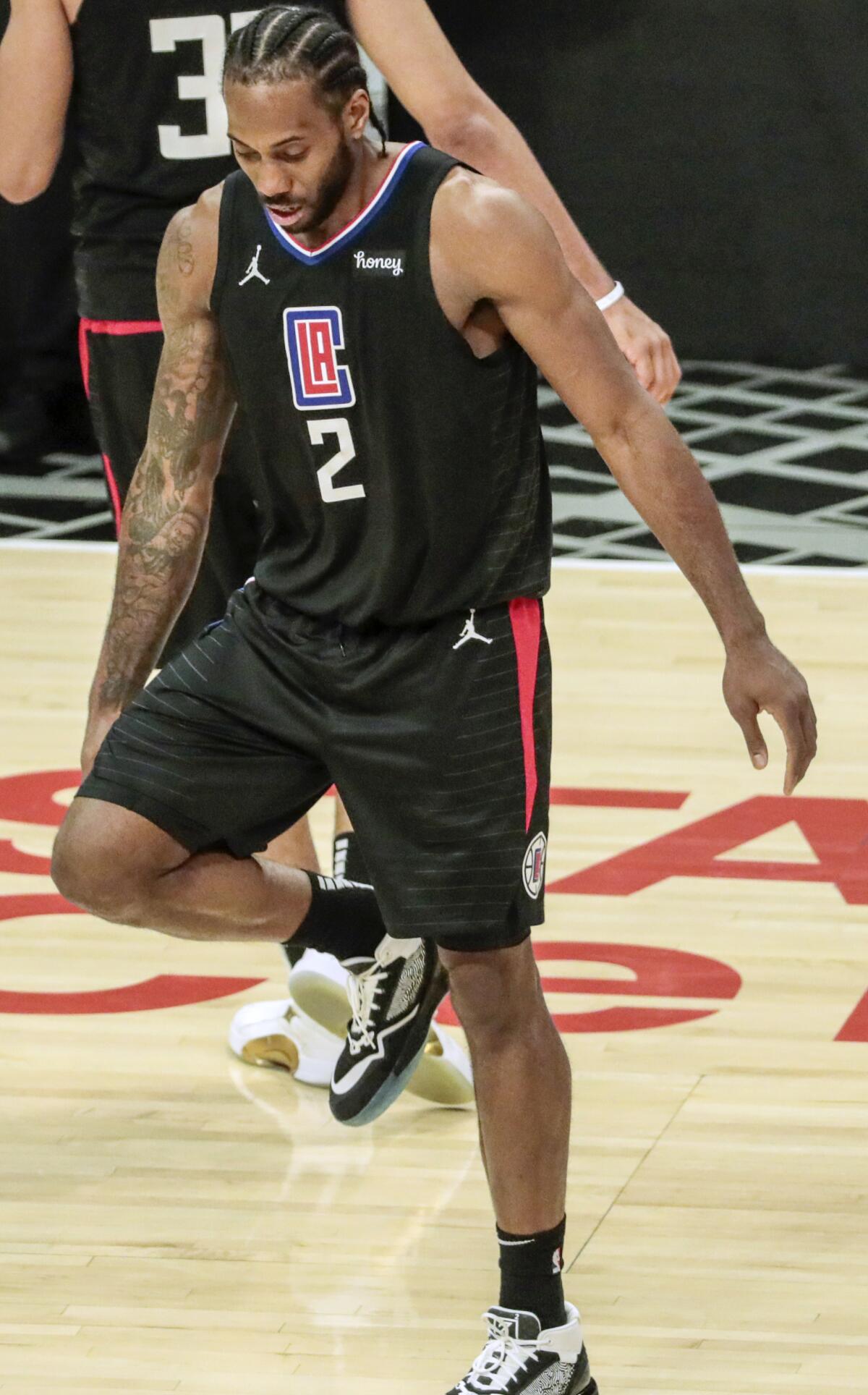 Clippers forward Kawhi Leonard stretches his right knee.