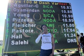 Freshman Jalen Carnes of Sierra Canyon poses in front of scoreboard of winning Mission League 100 meters in 10.83 seconds.