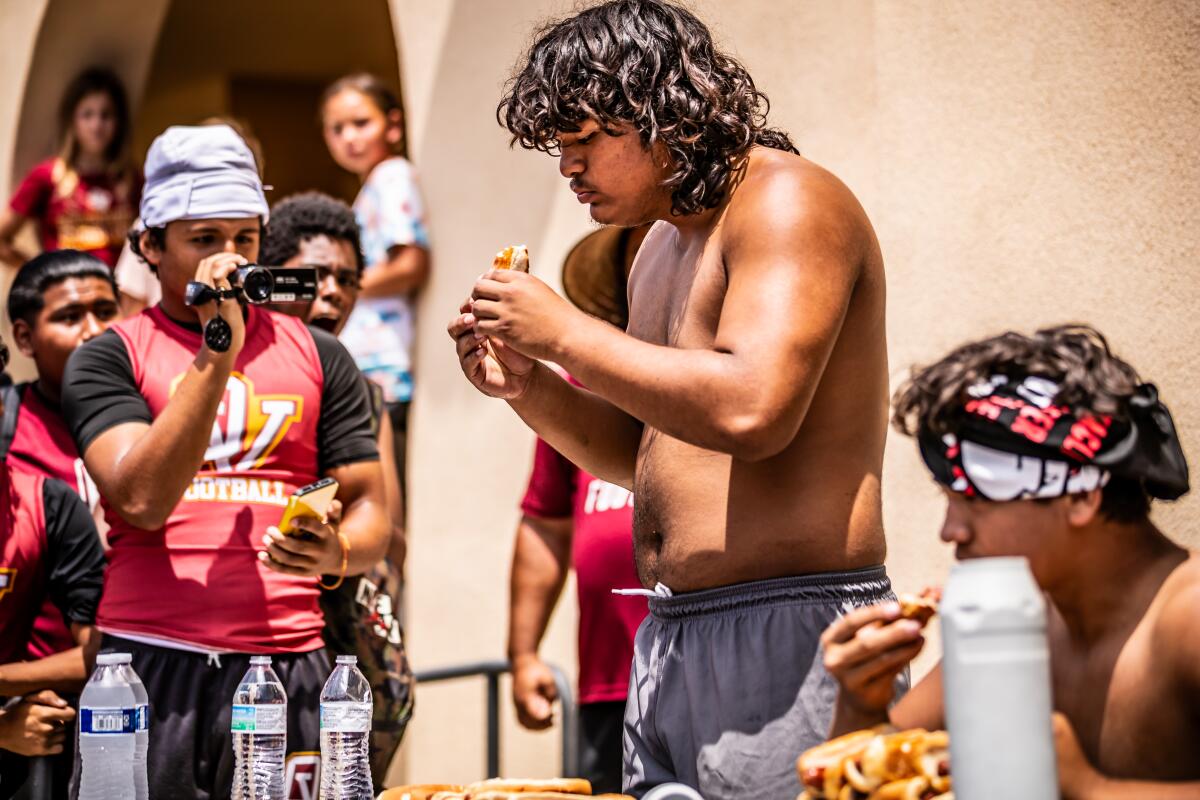 Ocean View's Pedro Maldonado receives support from teammates during a hotdog eating contest at Huntington Beach High.