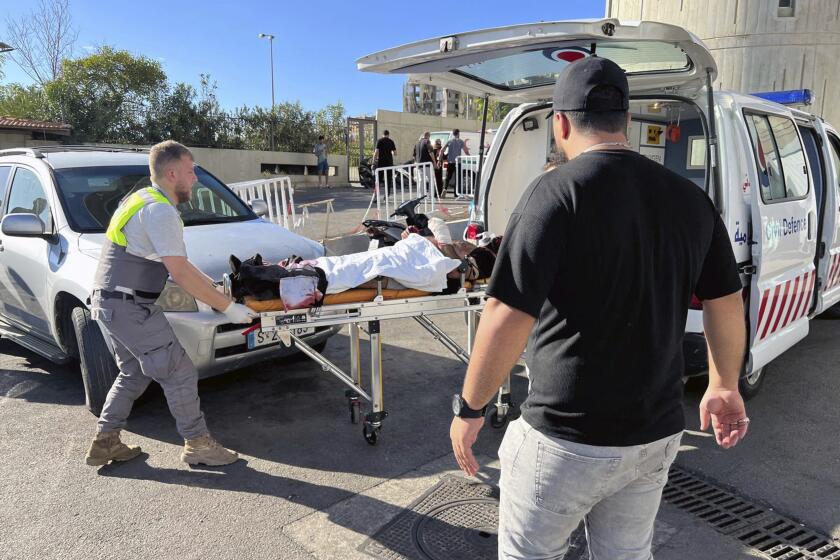 Personal de defensa civil ayuda a un hombre herido cuando estalló su buscapersonas, en Beirut, Líbano, el 17 de septiembre del 2024. (Foto AP/Hussein Malla)