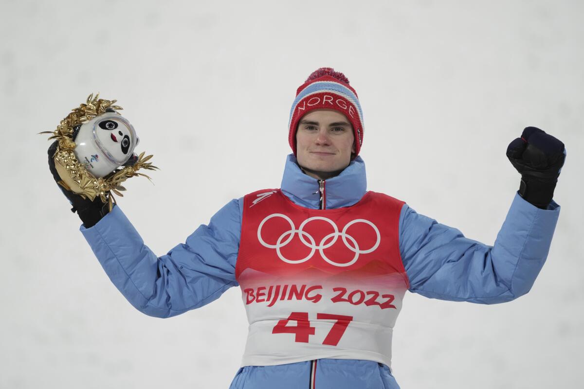 Marius Lindvik holds up his trophy at the 2022 Olympics