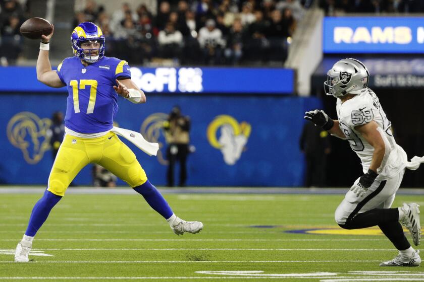 Rams quarterback Baker Mayfield finds an open receiver while scampering away from Las Vegas Raiders linebacker Luke Masterson