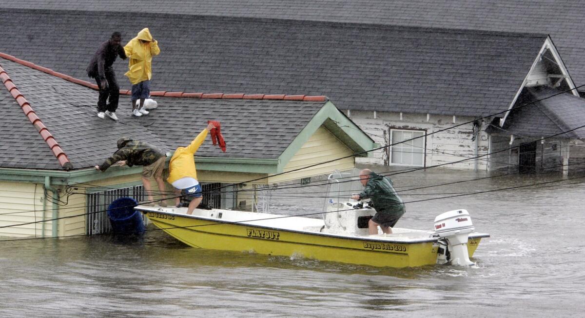 Boaters rescue Bryan Vernon and Dorothy Bell in New Orleans. Hundreds remained trapped on roofs or in attics. (Eric Gay / Associated Press)