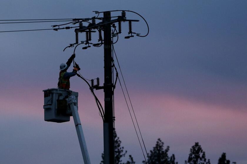 FILE - In this Nov. 26, 2018, file photo, a Pacific Gas & Electric lineman works to repair a power line in fire-ravaged Paradise, Calif. A U.S. judge who has berated Pacific Gas & Electric Co. for its role in wildfires in California is demanding more answers from the utility. In a court filing on Thursday, Feb. 14, 2019, Judge William Alsup asked PG&E whether it was in compliance with a state law that requires it to clear vegetation around electric lines. The judge also questioned a part of the utility's recently submitted wildfire mitigation plan. (AP Photo/Rich Pedroncelli, File)