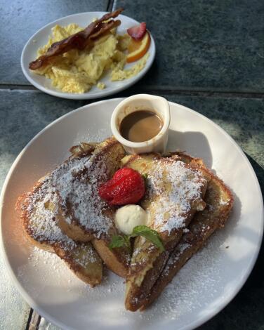 Classic Brioche French toast at Cafe Nouveau with scrambled eggs and bacon on the side.