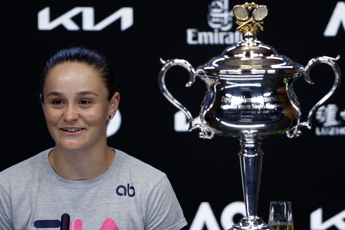 Ash Barty speaks next to a trophy.