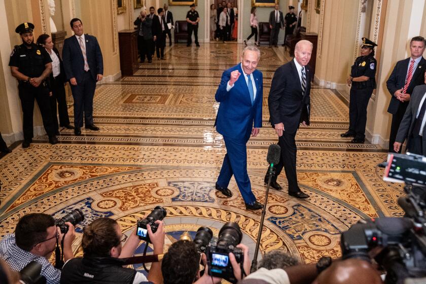WASHINGTON, DC - JULY 14: President Joe Biden, right, and Senate Majority Leader Chuck Schumer (D-NY), left, walk together through the senate side of the U.S. Capitol Building to meet with Senate Democrats during their luncheon on Wednesday, July 14, 2021. (Kent Nishimura / Los Angeles Times)