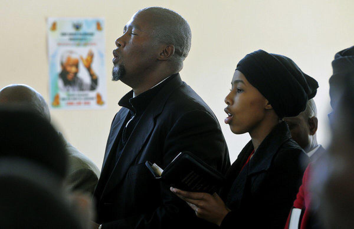 Mandla Mandela, left, grandson of former South African President Nelson Mandela, and his wife, Nodiyala, pray for the elder Mandela at a service in the village of Qunu, from which he removed the bodies of his grandfather's dead children, sparking a bitter family dispute.