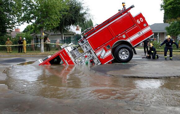 Los Angeles Fire Engine 60 was accidentally caught in a sinkhole that left the engine stuck in collapsing pavement at a 45-degree angle about 5:20 a.m. this morning. A water main rupture caused the sinkhole in Valley Village.