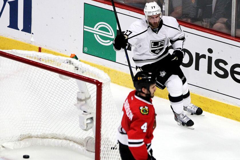 Kings forward Jeff Carter celebrates after scoring one of his three goals in the third period against defenseman Niklas Hjalmarsson and the Blackhawks on Wednesday night in Chicago.