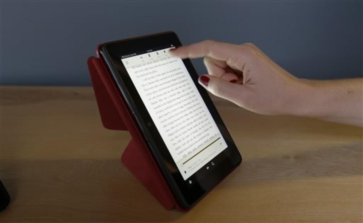 The 7-inch Amazon Kindle HDX, is shown on the optional folding "Origami" stand that also protects the screen when not in use, Tuesday, Sept. 24, 2013, in Seattle. Amazon has refreshed its line-up of tablets with two new HDX devices, which are significantly faster and lighter than the previous generation. (AP Photo/Ted S. Warren)
